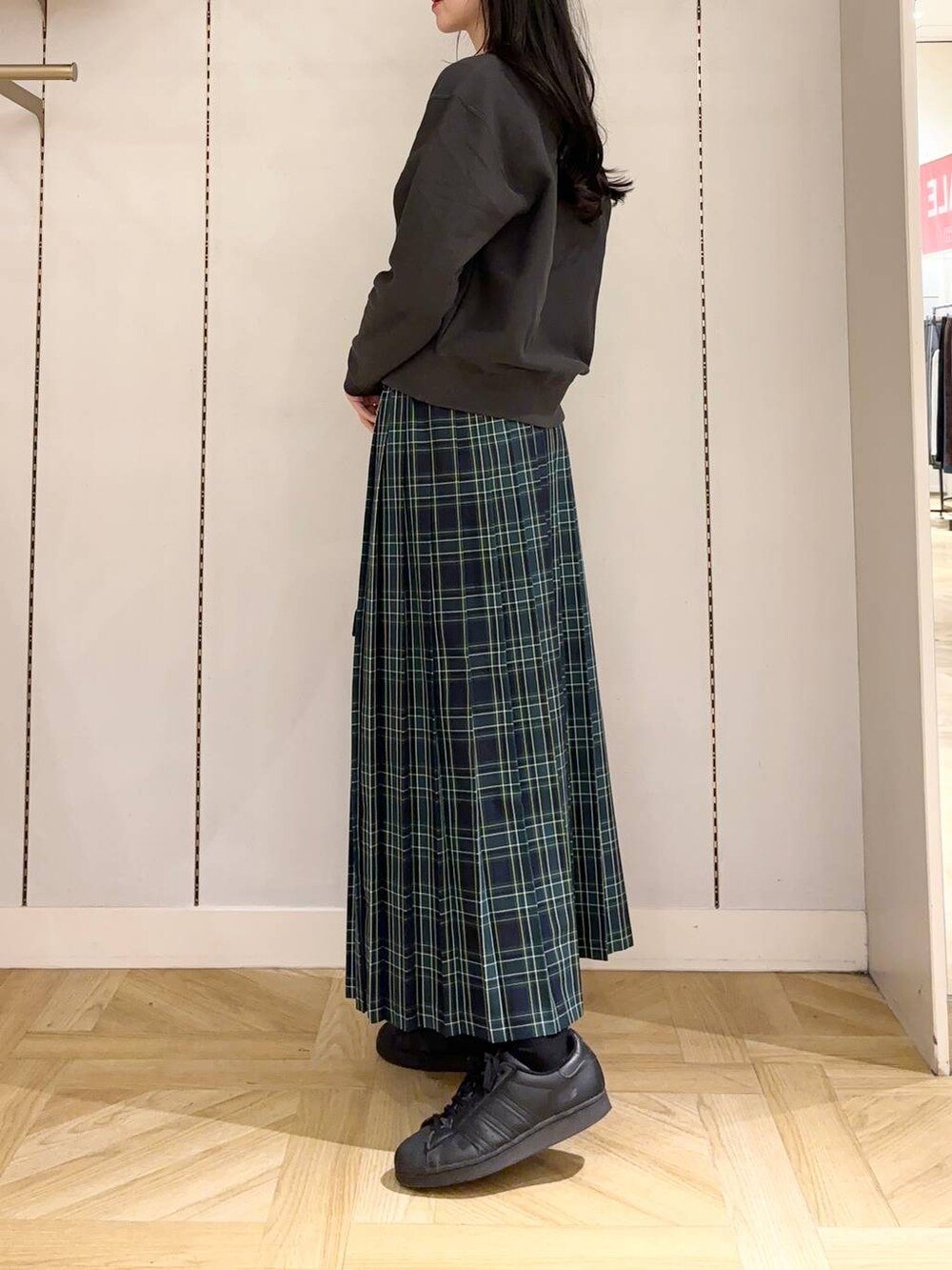 ブラック系のショルダーバッグ、グレー系のスウェット、ブルー系のスカートを着用したレディースの冬コーディネートの2枚目の写真