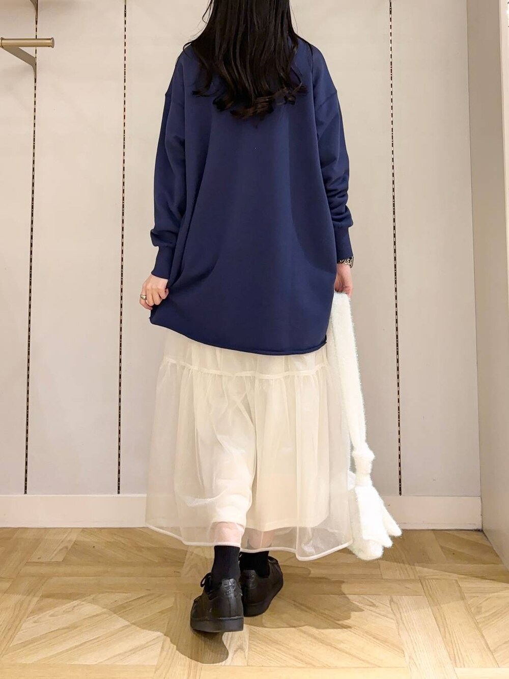 ホワイト系のショルダーバッグ、ホワイト系のスカート、ブルー系のワンピースを着用したレディースの冬コーディネートの3枚目の写真