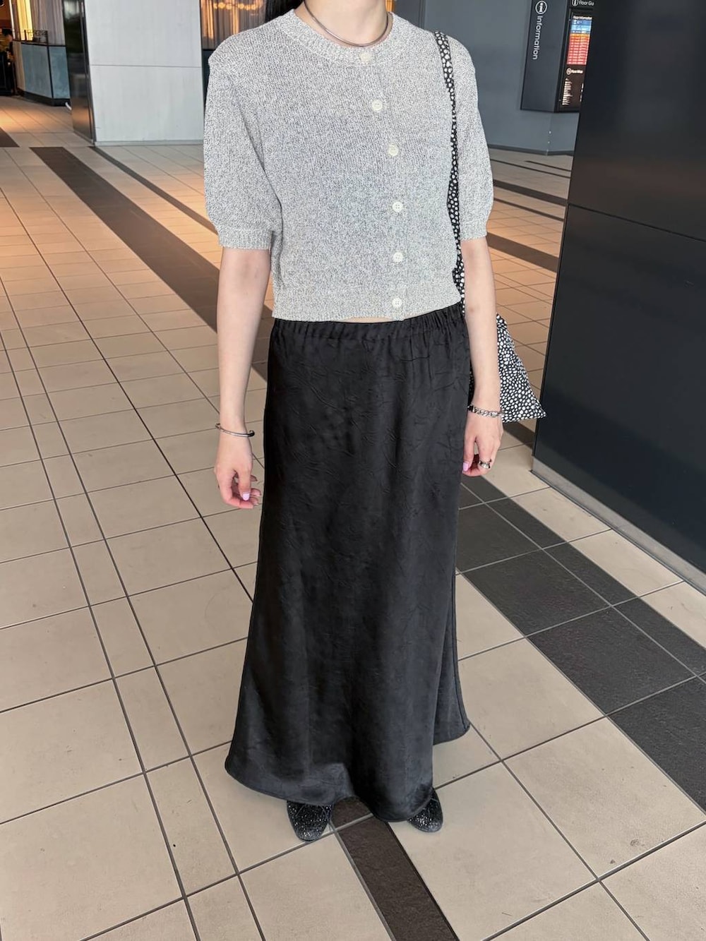 ブラック系のスカート、グレー系のTシャツ/カットソーを着用したレディースの夏コーディネートの2枚目の写真