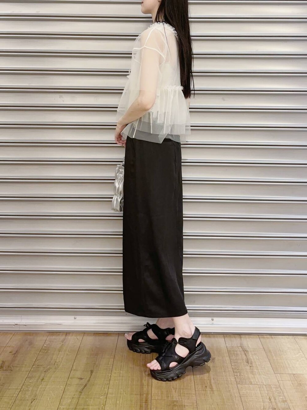 ブラック系のサンダル、グレー系のショルダーバッグ、ホワイト系のシャツ/ブラウスを着用したレディースの夏コーディネートの2枚目の写真