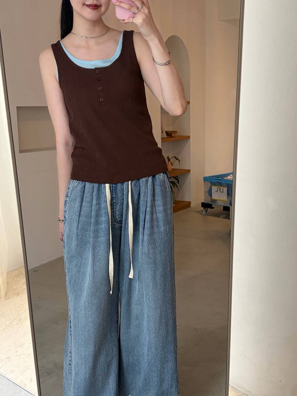 ブルー系のデニムパンツ、ブラウン系のタンクトップを着用したレディースの夏コーディネートの2枚目の写真