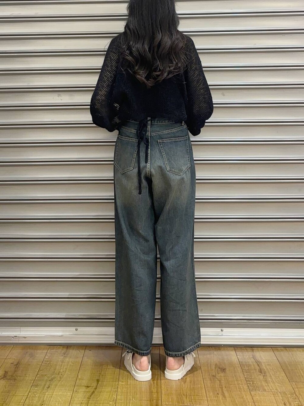 ブルー系のデニムパンツ、ブラック系のショルダーバッグ、ブラック系のカーディガン/ボレロを着用したレディースの夏コーディネートの3枚目の写真