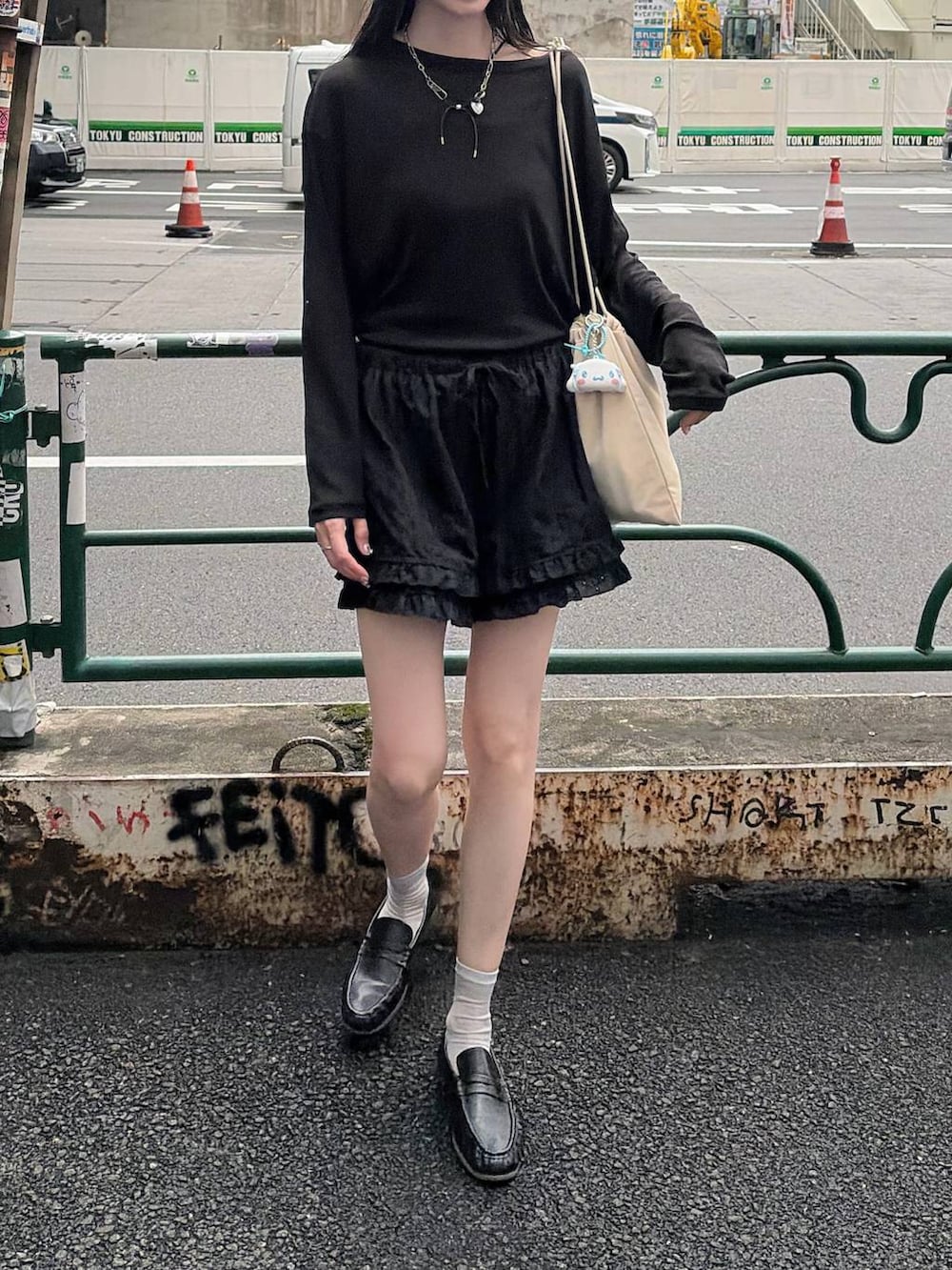 ホワイト系のショルダーバッグ、ブラック系のTシャツ/カットソーを着用したレディースの秋コーディネートの2枚目の写真