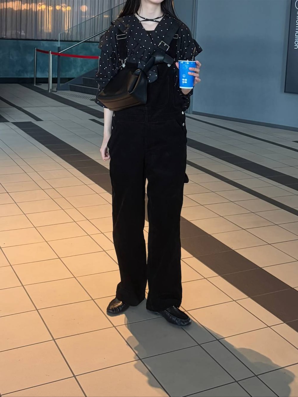 ブラック系のサロペット/オーバーオール、ブラック系のショルダーバッグを着用したレディースの春コーディネートの2枚目の写真