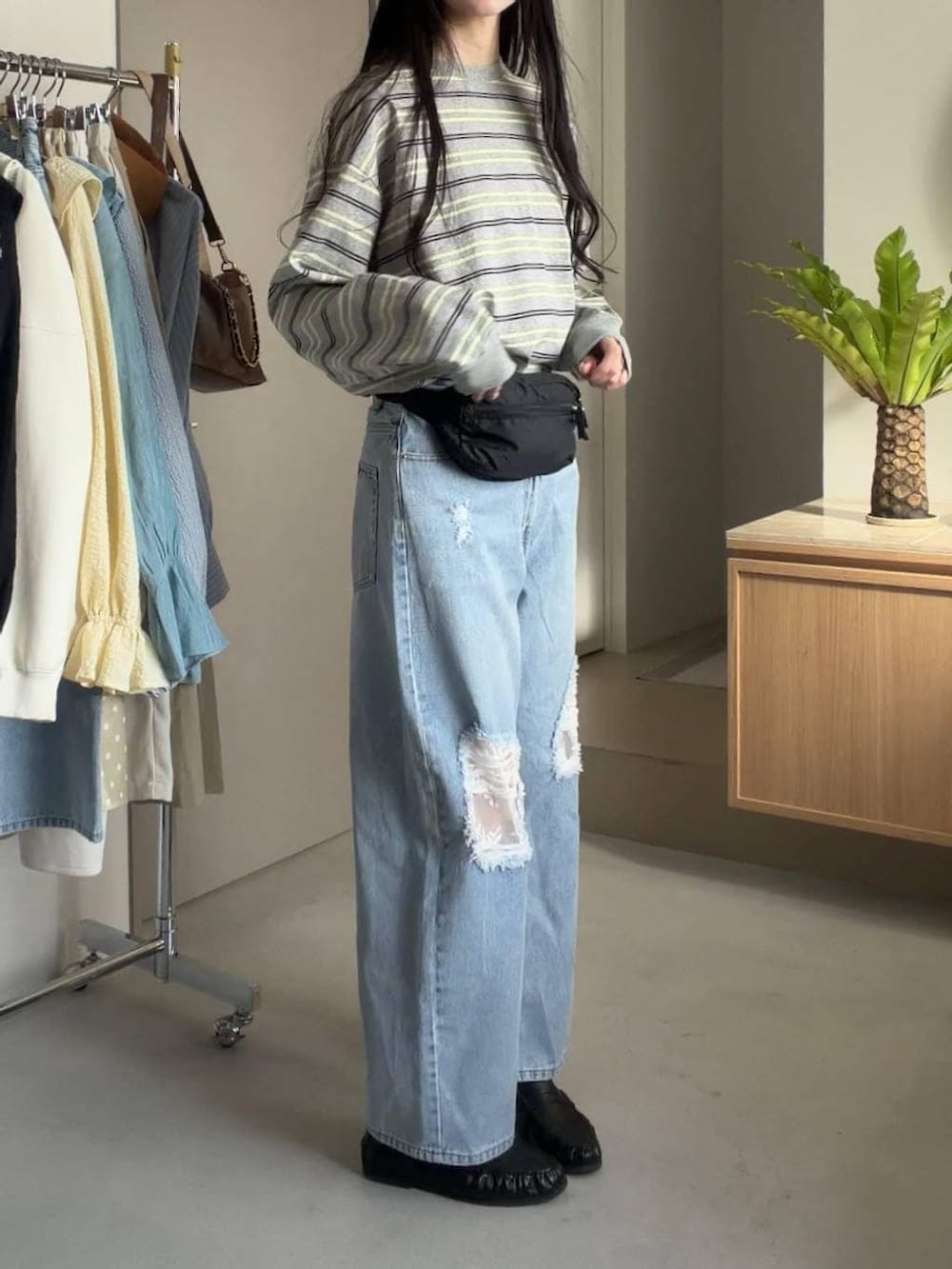 ブルー系のデニムパンツ、ブラック系のボディバッグ/ウエストポーチを着用したレディースの冬コーディネートの2枚目の写真