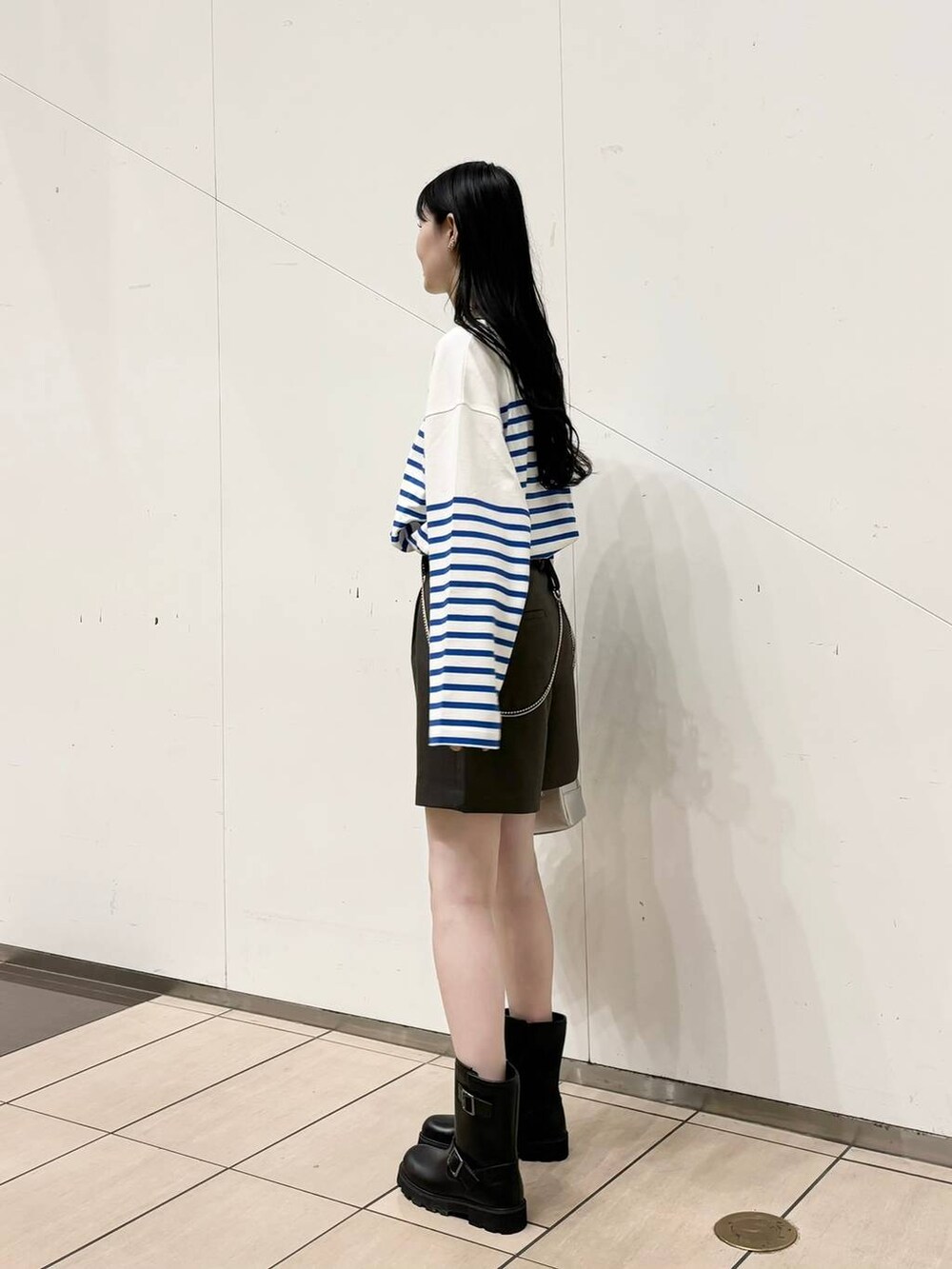 ブラック系のブーツ、シルバー系のボストンバッグ、グレー系のその他パンツを着用したレディースの秋コーディネートの2枚目の写真