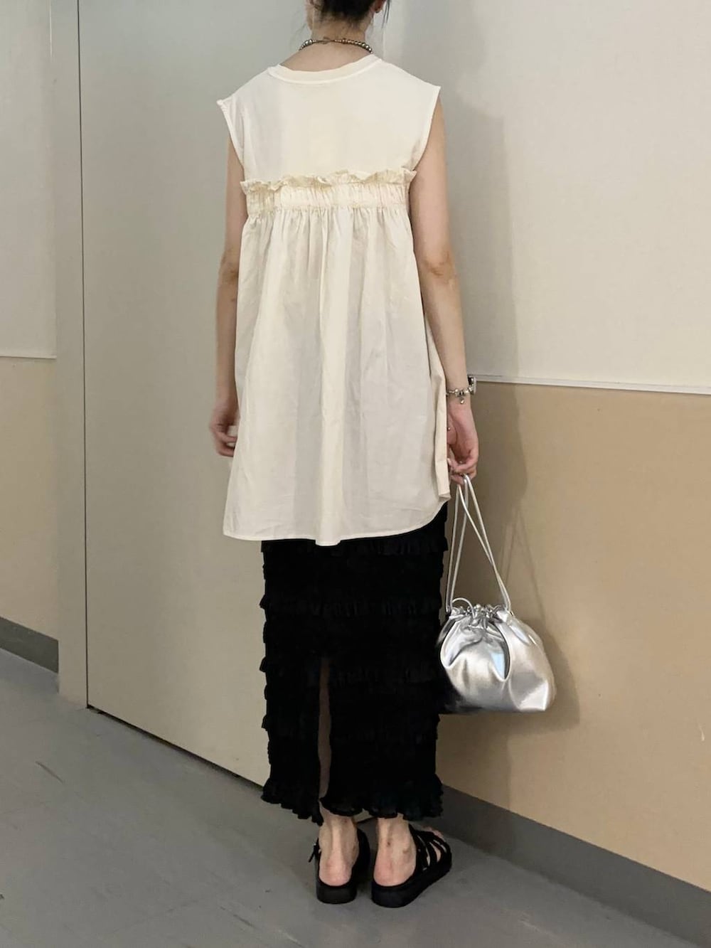 ホワイト系のTシャツ/カットソー、ブラック系のスニーカー、シルバー系のショルダーバッグを着用したレディースの夏コーディネートの3枚目の写真