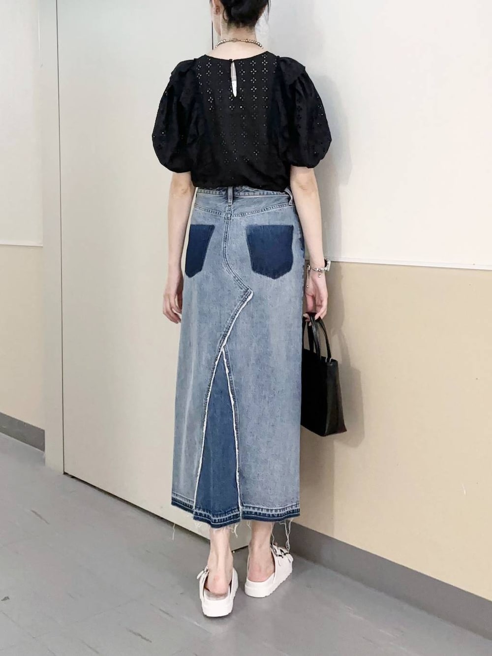 ブラック系のショルダーバッグ、ブルー系のスカート、ホワイト系のサンダルを着用したレディースの夏コーディネートの3枚目の写真