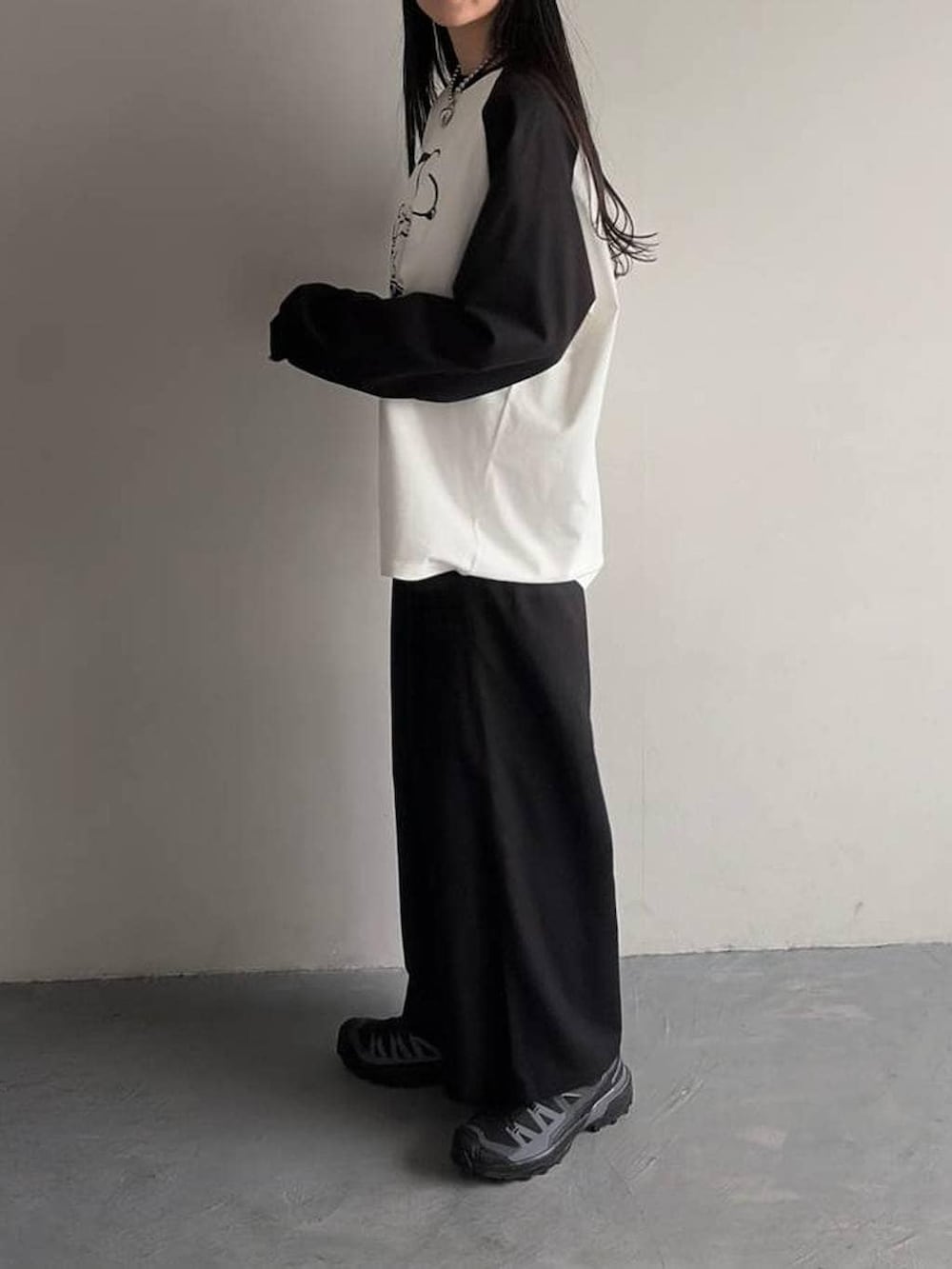 ブラック系のスラックス、ホワイト系のTシャツ/カットソーを着用したレディースの春コーディネートの3枚目の写真