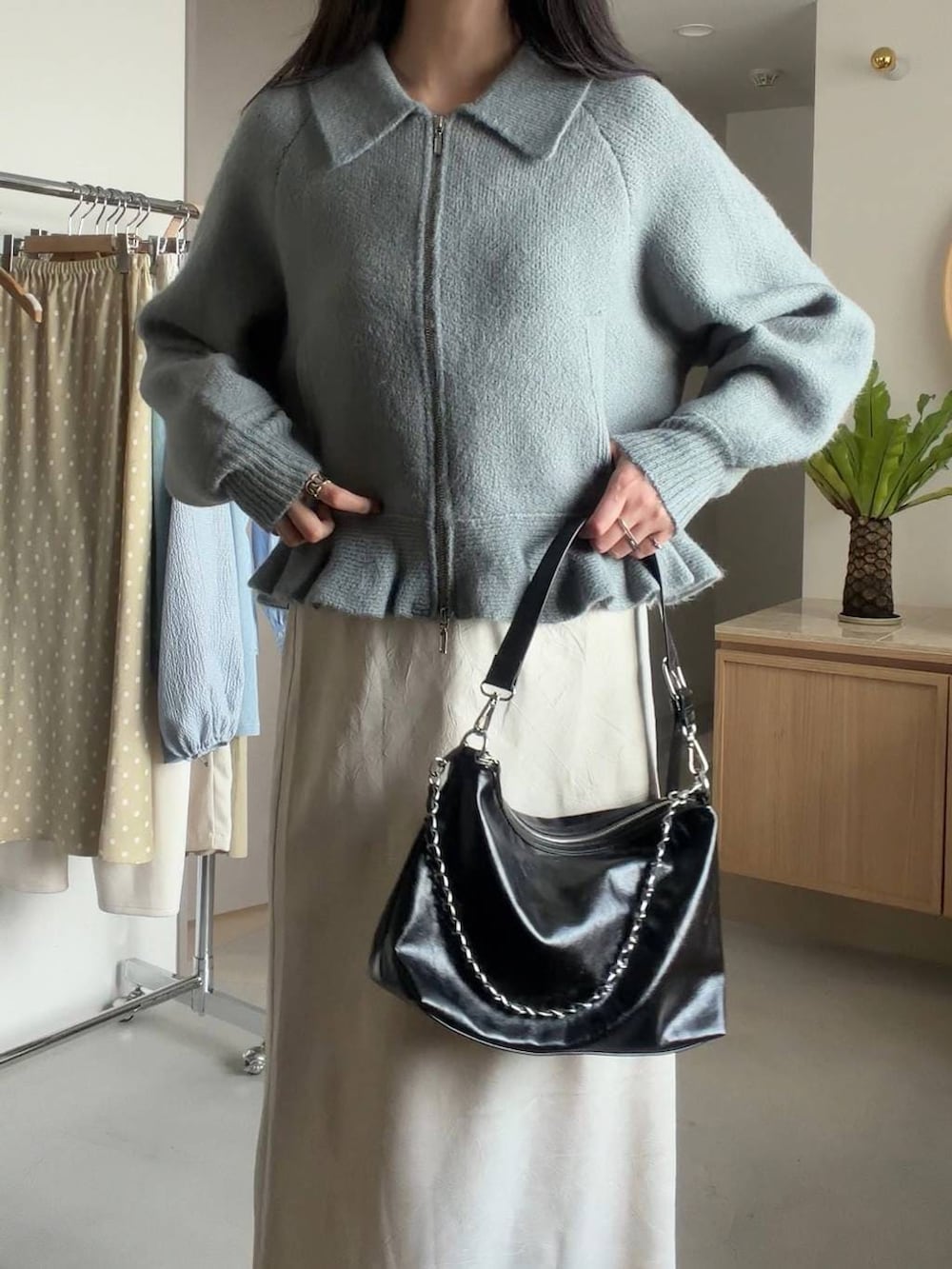 ホワイト系のスカート、ブラック系のショルダーバッグ、グリーン系のブルゾンを着用したレディースの冬コーディネートの5枚目の写真