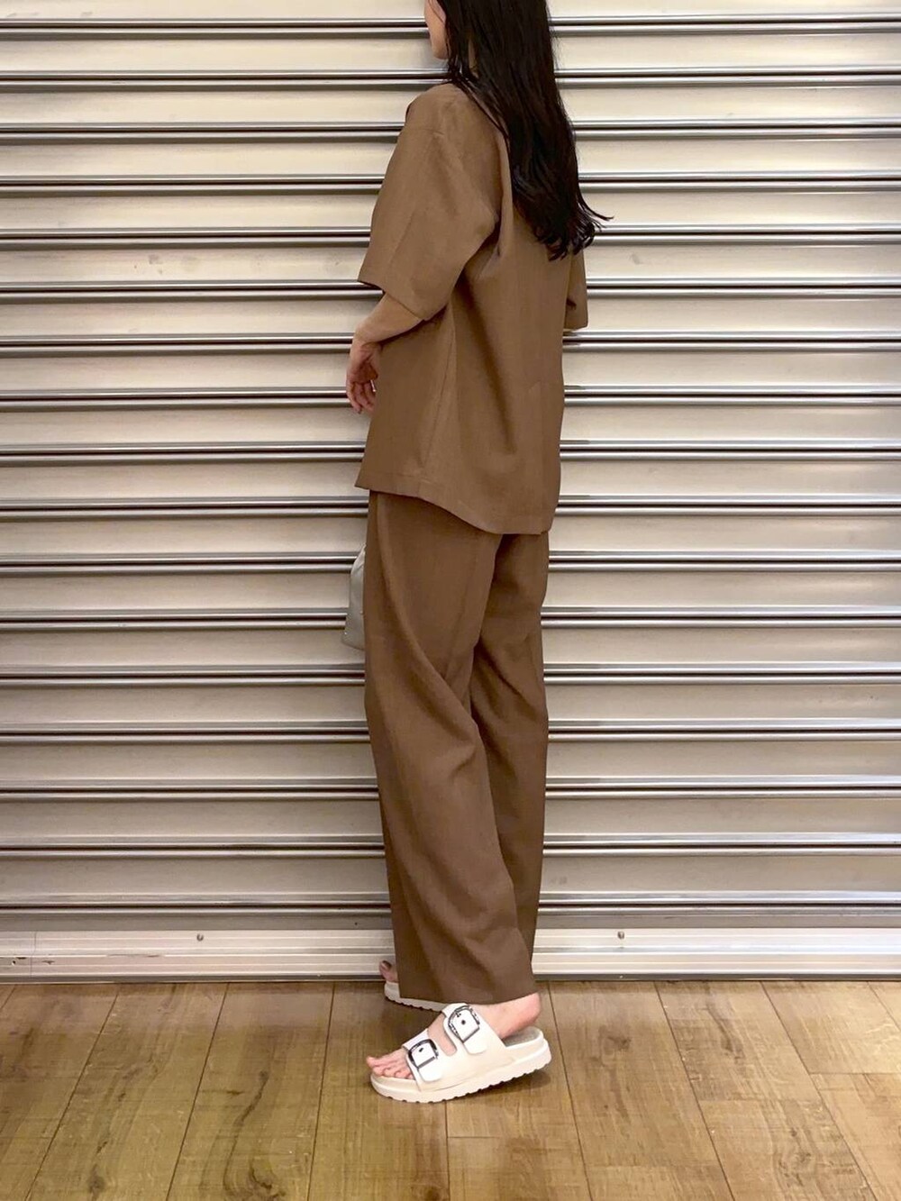 シルバー系のショルダーバッグ、ホワイト系のサンダル、ホワイト系のタンクトップを着用したレディースの夏コーディネートの2枚目の写真