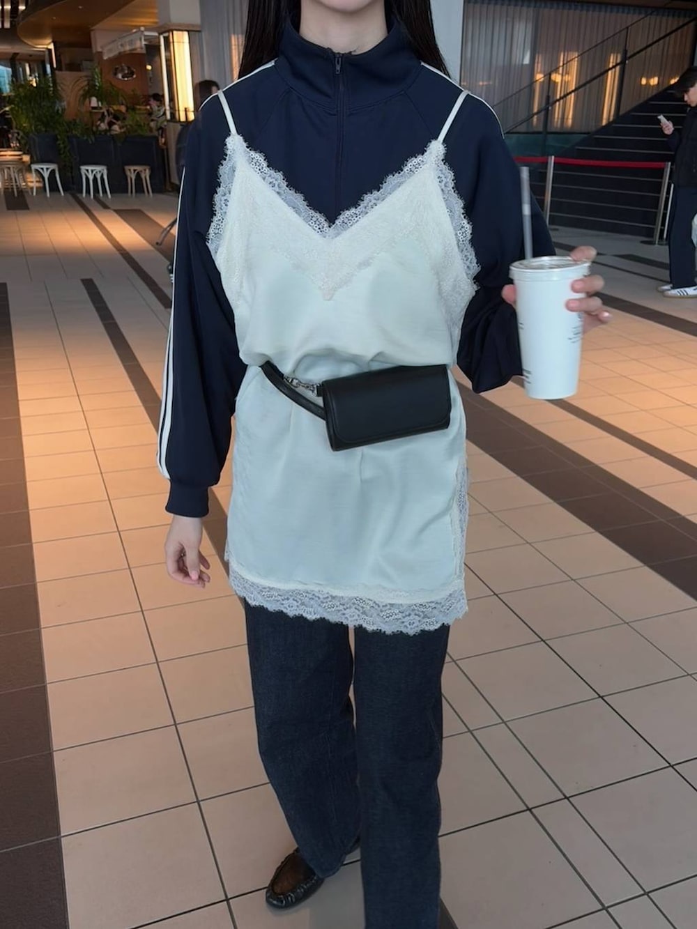 ブラック系のボディバッグ/ウエストポーチを着用したレディースの春コーディネートの2枚目の写真