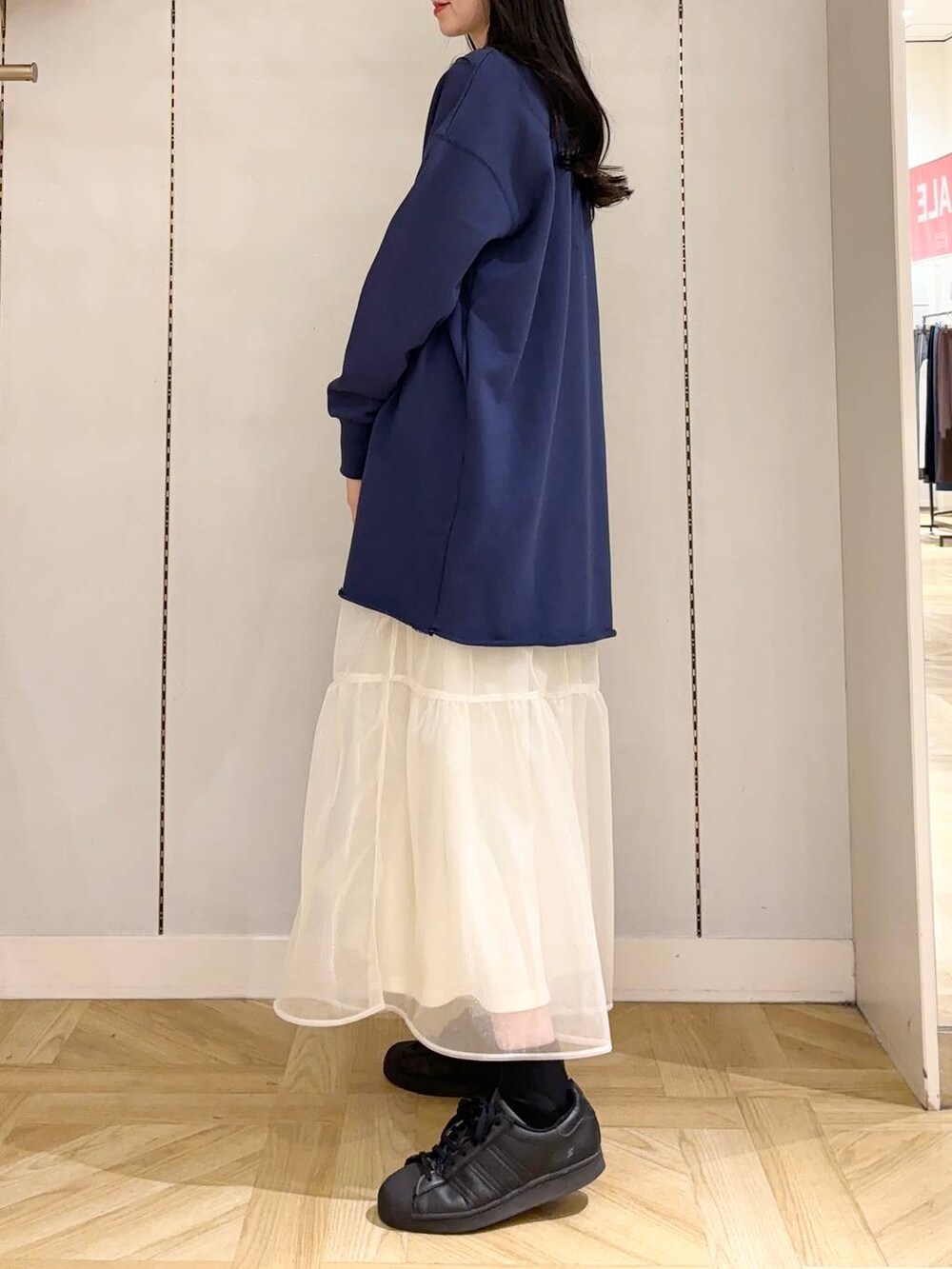 ホワイト系のショルダーバッグ、ホワイト系のスカート、ブルー系のワンピースを着用したレディースの冬コーディネートの2枚目の写真