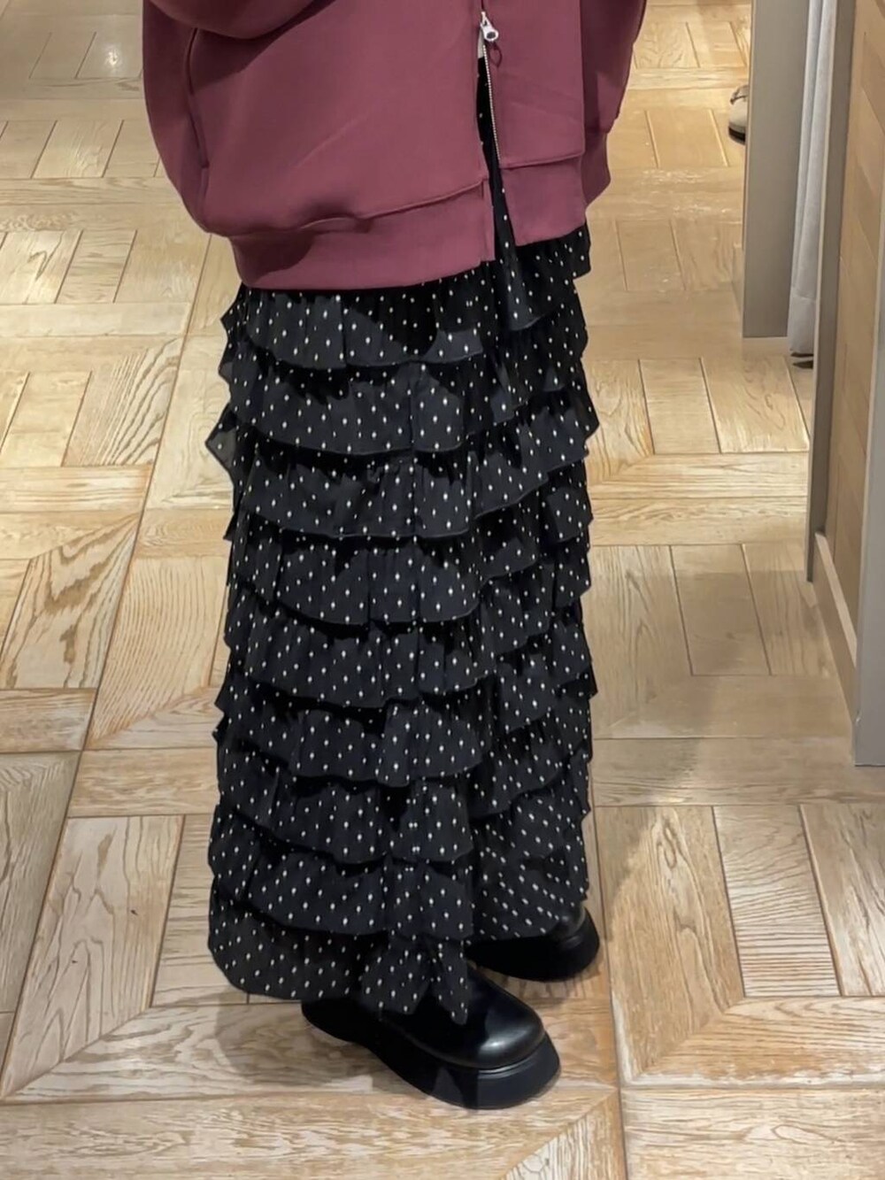 レッド系のパーカー、その他のスカート、ブラック系のサンダルを着用したレディースの秋コーディネートの3枚目の写真