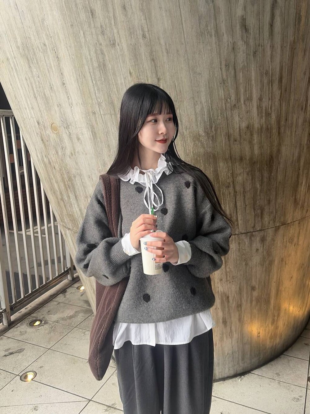 ホワイト系のシャツ/ブラウス、グレー系のニット/セーターを着用したレディースの冬コーディネートの2枚目の写真