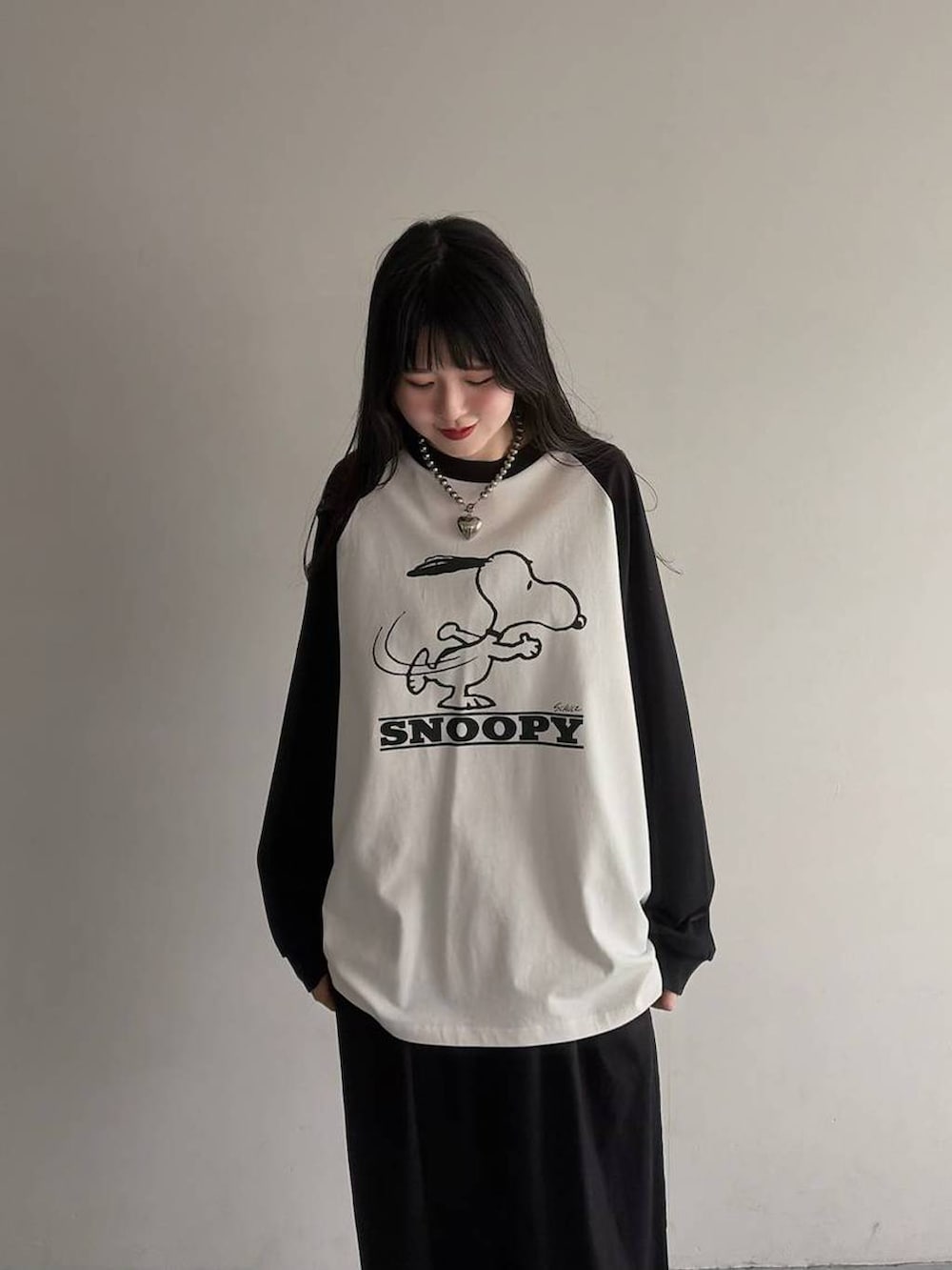 ブラック系のスラックス、ホワイト系のTシャツ/カットソーを着用したレディースの春コーディネートの2枚目の写真