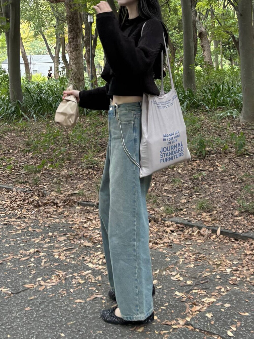 ブラック系のTシャツ/カットソー、ブルー系のデニムパンツ、ブラック系のニット/セーターを着用したレディースの秋コーディネートの3枚目の写真