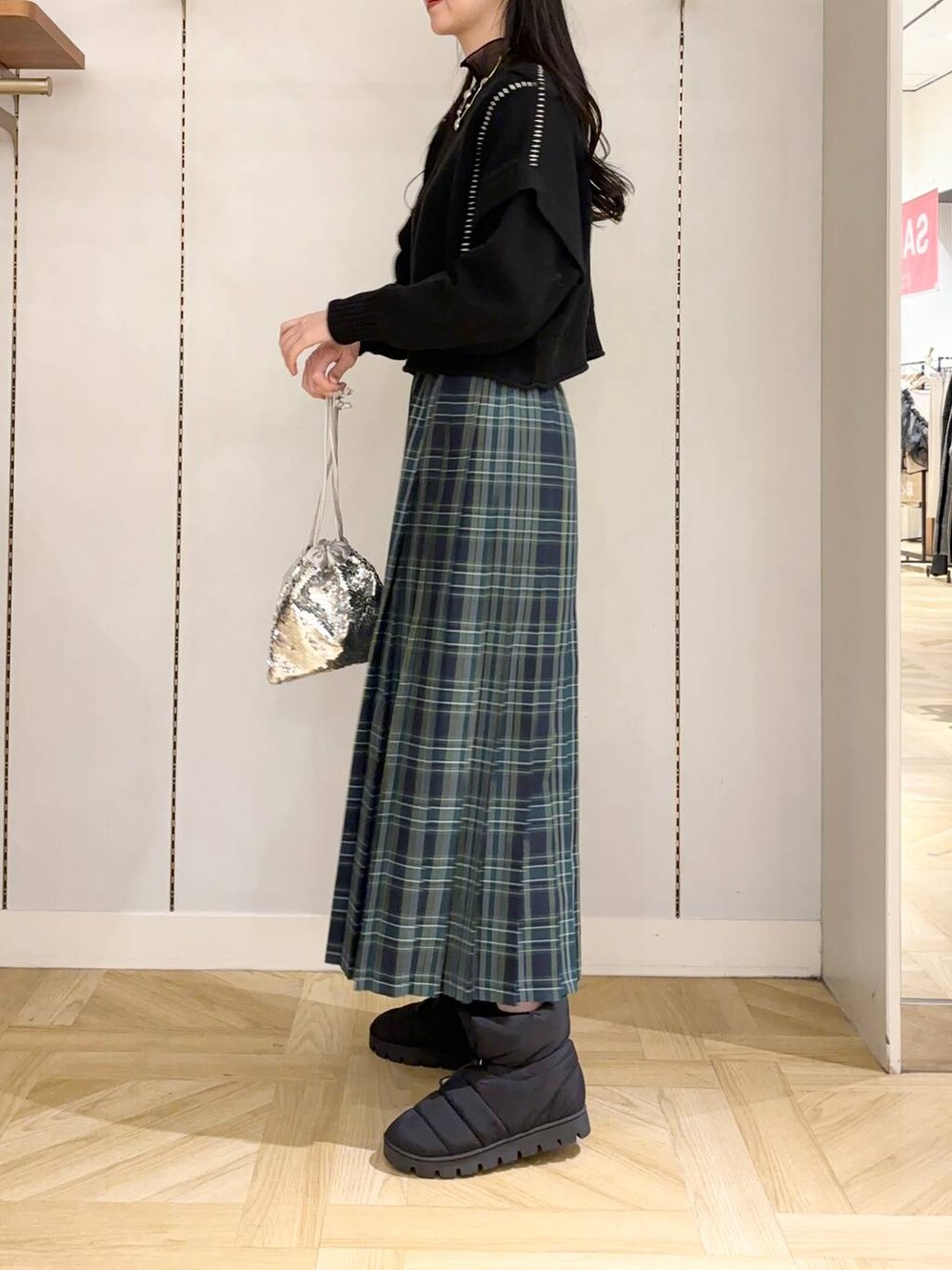 ブラック系のTシャツ/カットソー、シルバー系のハンドバッグ、ブラック系のブーツを着用したレディースの冬コーディネートの2枚目の写真