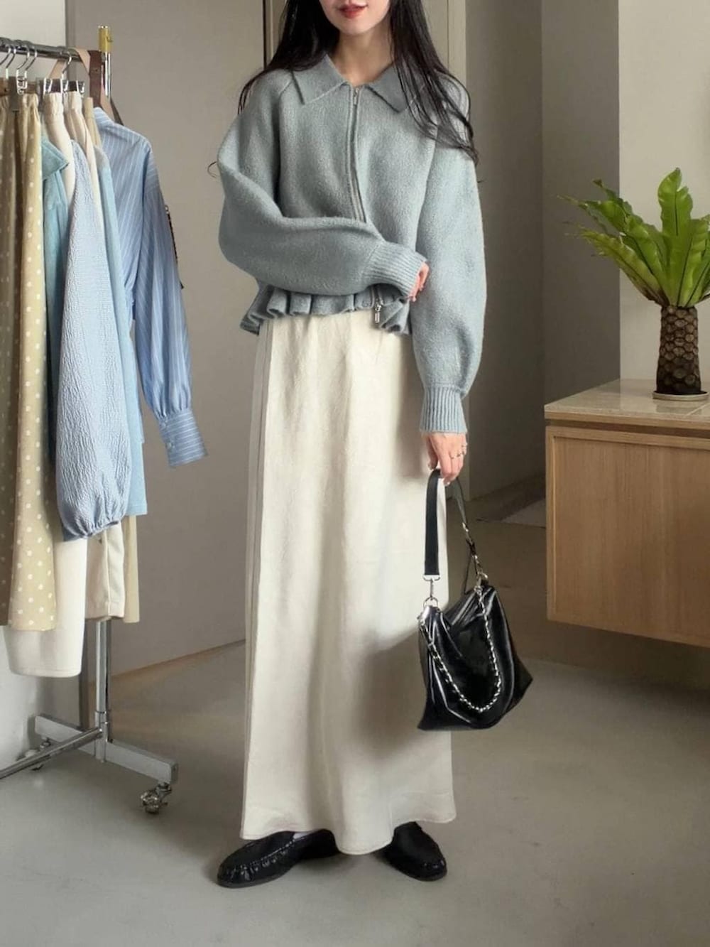 ホワイト系のスカート、ブラック系のショルダーバッグ、グリーン系のブルゾンを着用したレディースの冬コーディネートの2枚目の写真