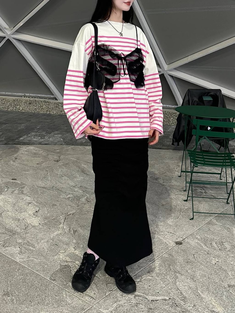 ブラック系のスカート、ピンク系のTシャツ/カットソー、ピンク系のソックス/靴下を着用したレディースの春コーディネートの2枚目の写真