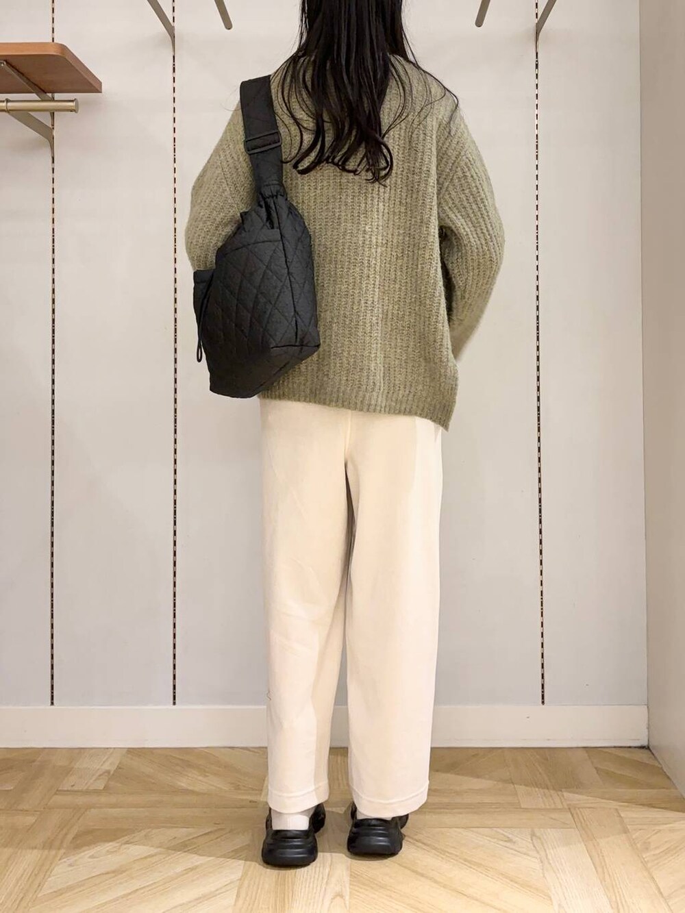 ブラック系のショルダーバッグ、ホワイト系のブーツ、グリーン系のTシャツ/カットソーを着用したレディースの冬コーディネートの3枚目の写真