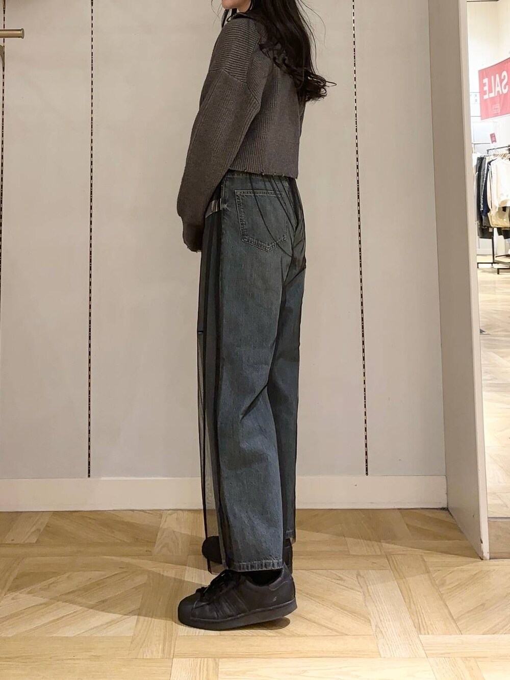 ブラック系のその他パンツ、ブラック系のショルダーバッグ、ブルー系のデニムパンツを着用したレディースの冬コーディネートの2枚目の写真