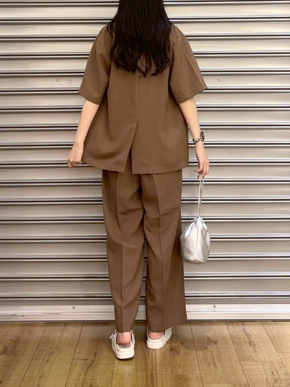 シルバー系のショルダーバッグ、ホワイト系のサンダル、ホワイト系のタンクトップを着用したレディースの夏コーディネートの3枚目の写真