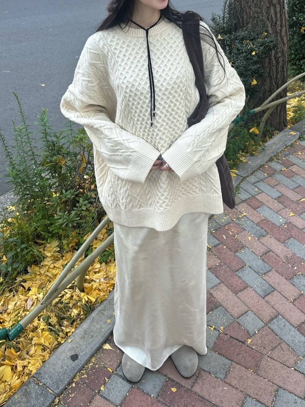 ホワイト系のスカート、ホワイト系のニット/セーター、シルバー系のネックレスを着用したレディースの冬コーディネートの2枚目の写真