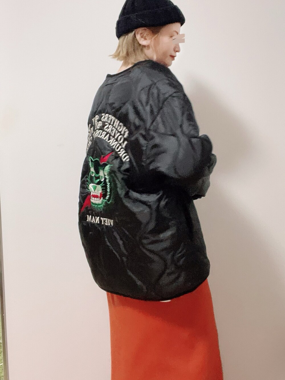 ホワイト系のTシャツ/カットソー、ブラック系のミリタリージャケット、レッド系のスカートを着用したレディースの冬コーディネートの2枚目の写真