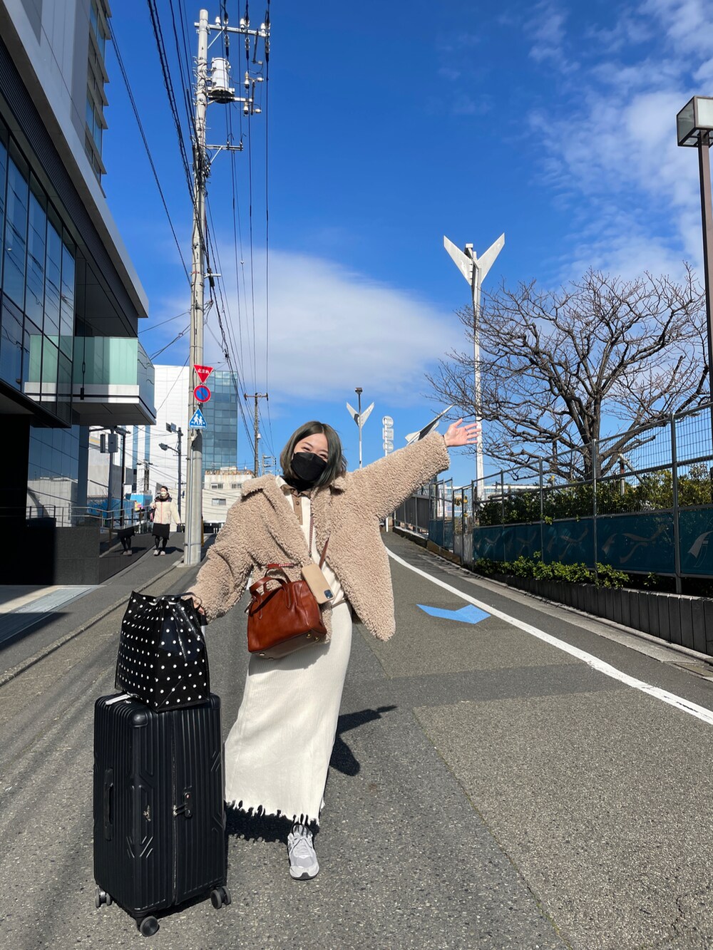 ベージュ系のその他アウター、ベージュ系のスカート、ブラウン系のボストンバッグを着用したレディースの冬コーディネートの2枚目の写真