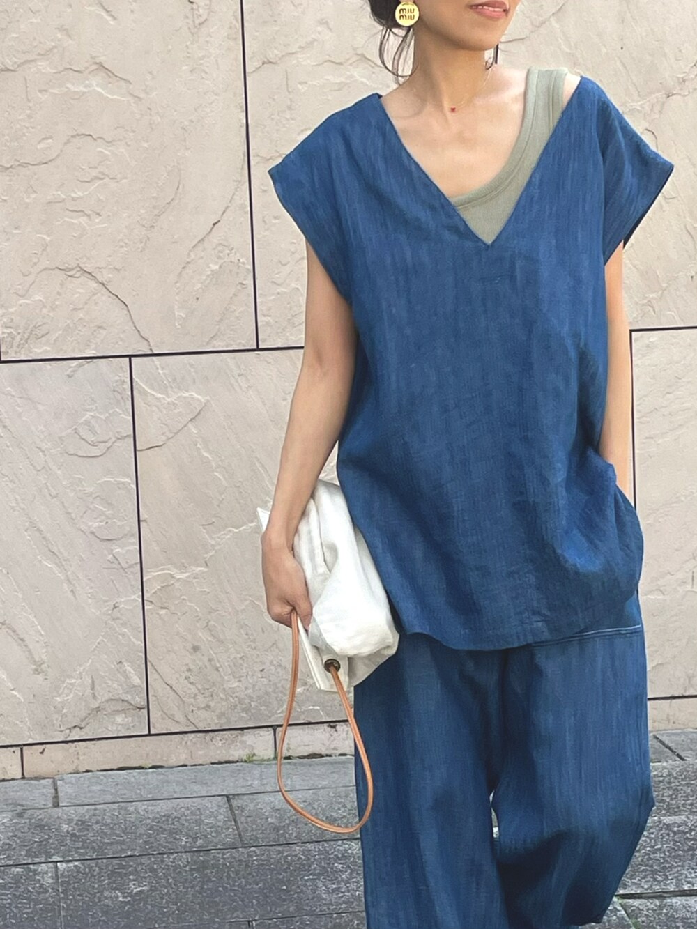 ブルー系のベスト、ブルー系のデニムパンツを着用したレディースの春コーディネートの3枚目の写真