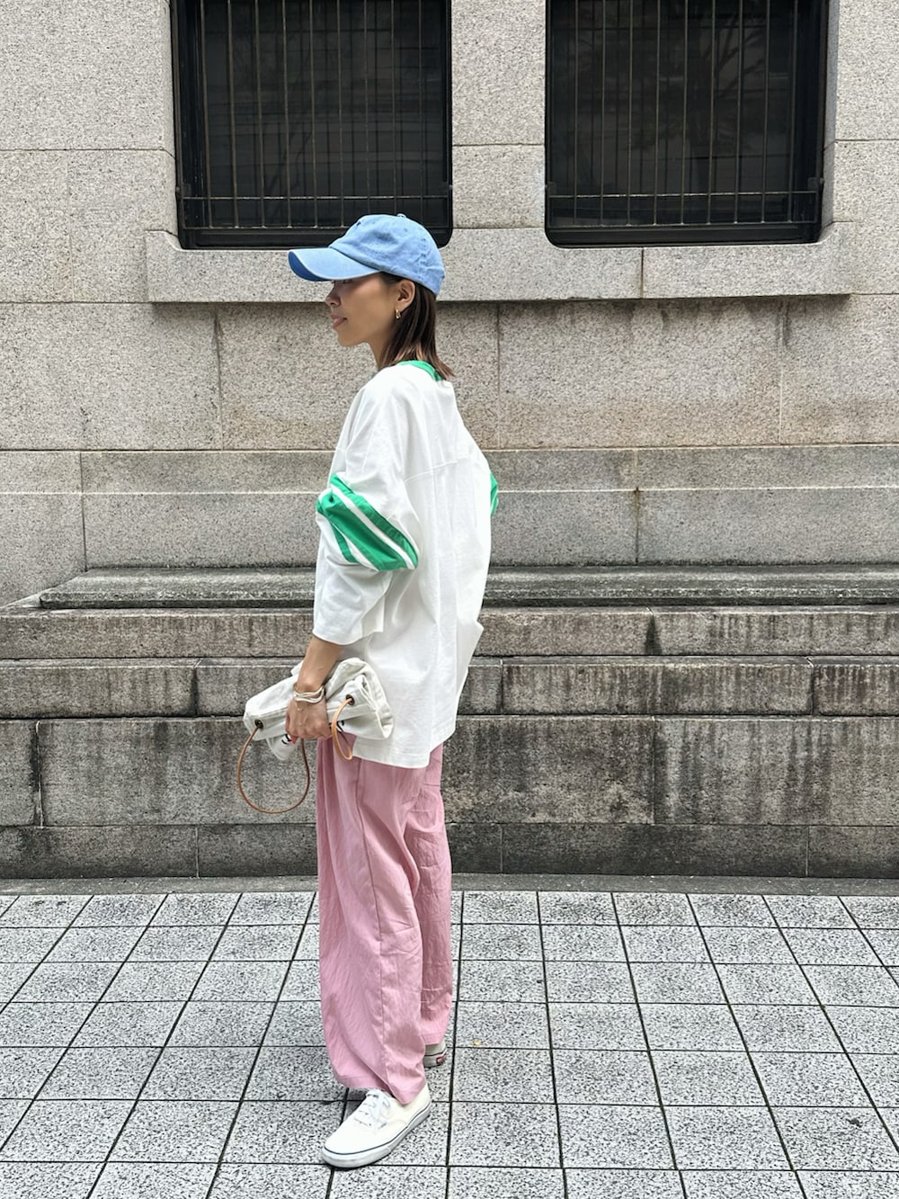 グリーン系のTシャツ/カットソー、ピンク系のスラックス、ホワイト系のスニーカーを着用したレディースの春コーディネートの2枚目の写真