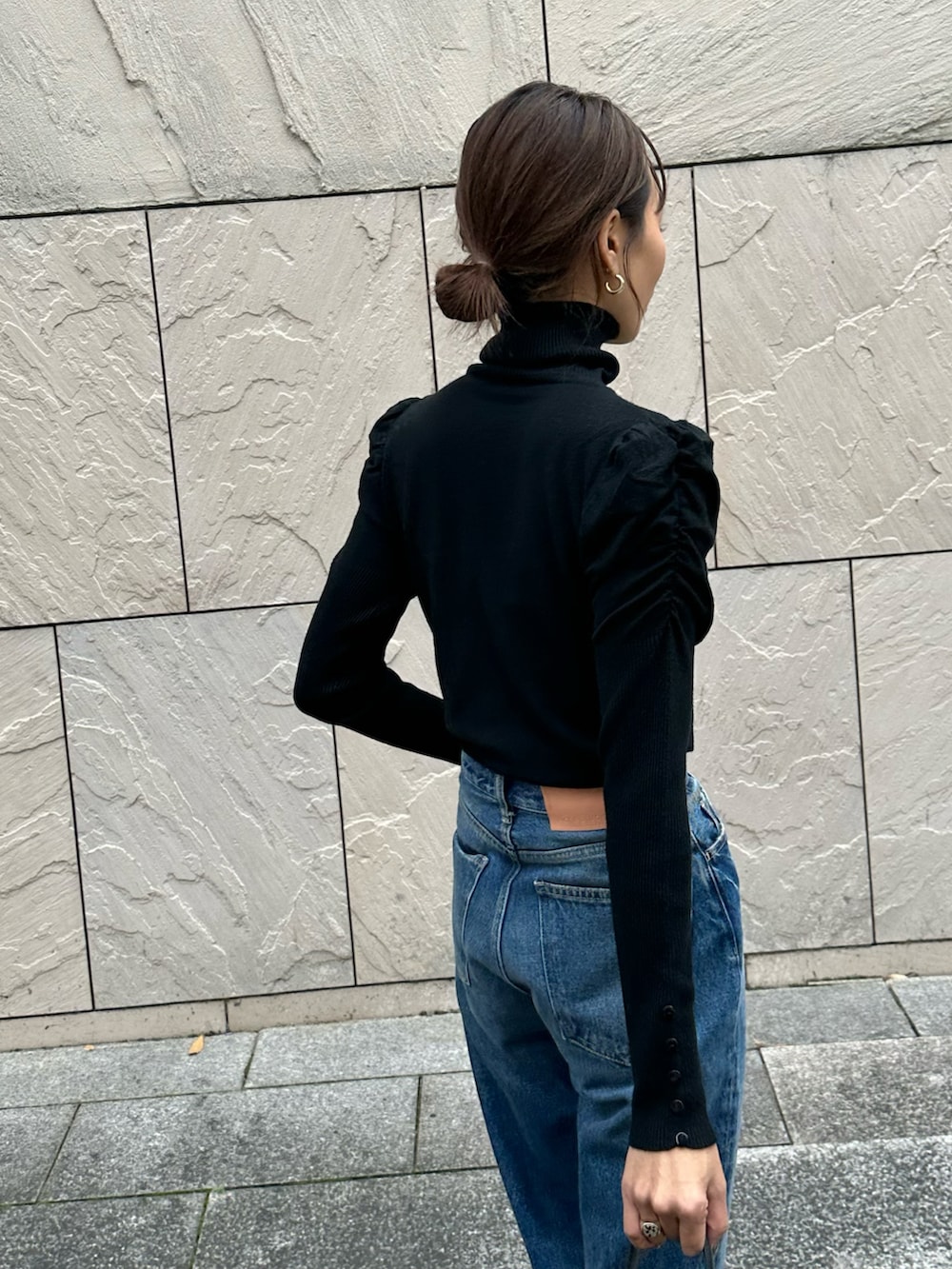 ブラック系のニット/セーター、ブルー系のデニムパンツを着用したレディースの冬コーディネートの2枚目の写真