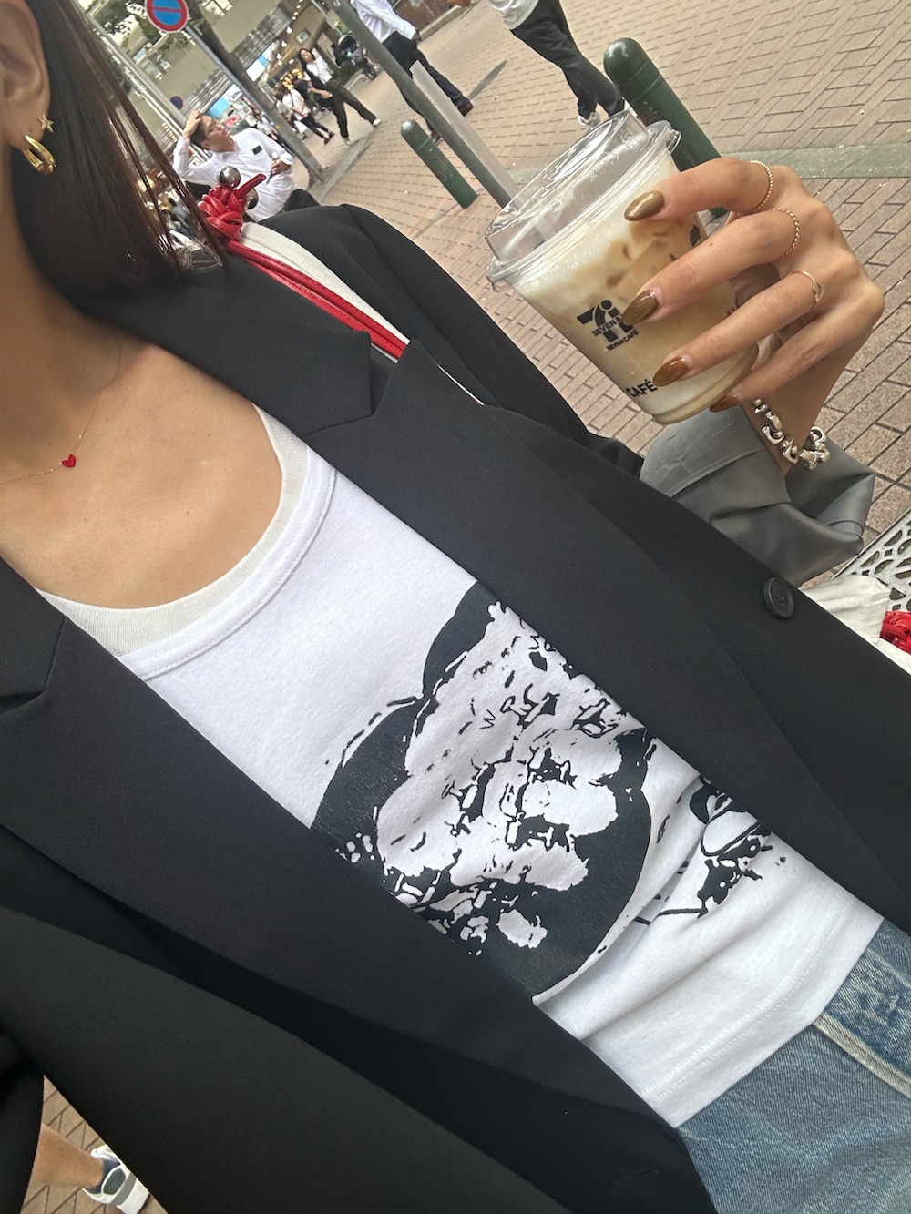 レッド系のショルダーバッグ、ブラック系のテーラードジャケットを着用したレディースの秋コーディネートの2枚目の写真