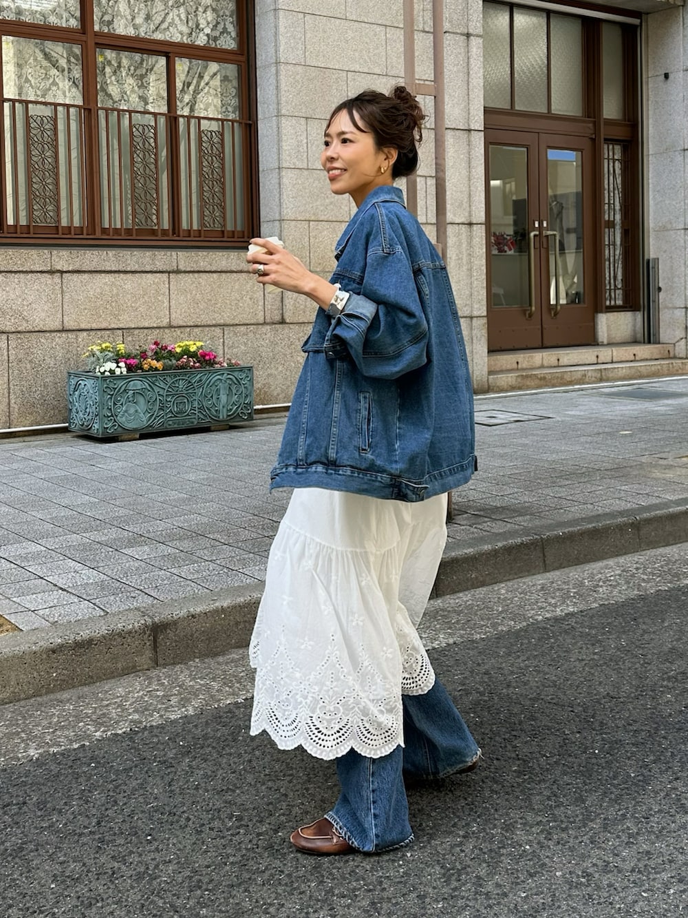 ホワイト系のスカート、ブルー系のデニムジャケットを着用したレディースの春コーディネートの2枚目の写真