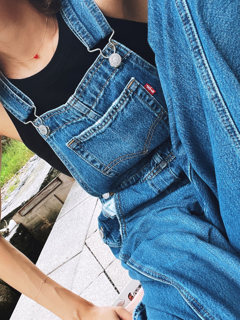 ブルー系のサロペット/オーバーオール、ブラック系のタンクトップを着用したレディースの夏コーディネートの2枚目の写真