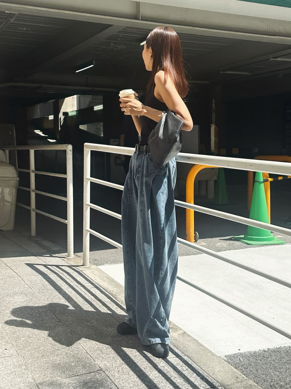 ブルー系のデニムパンツ、ブラック系のタンクトップを着用したレディースの夏コーディネートの2枚目の写真