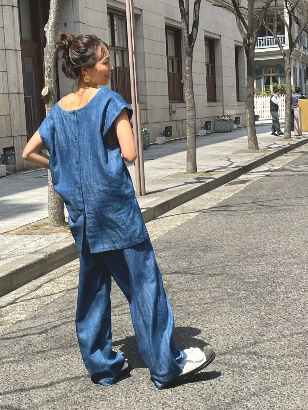 ブルー系のベスト、ブルー系のデニムパンツを着用したレディースの春コーディネートの2枚目の写真