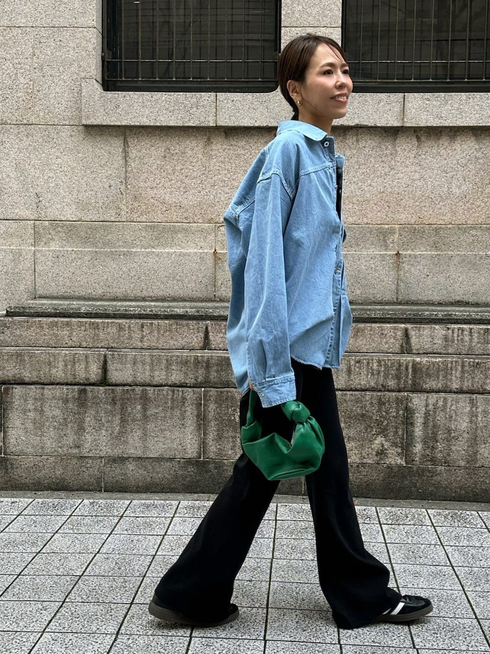 ブルー系のデニムジャケット、ブラック系のスウェットパンツを着用したレディースの春コーディネートの2枚目の写真