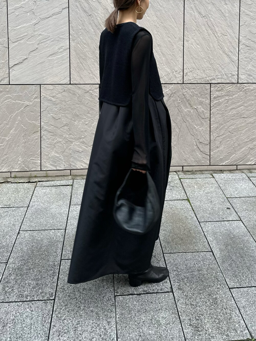 ブラック系のワンピース、ブラック系のTシャツ/カットソー、ブラック系のブーツを着用したレディースの冬コーディネートの3枚目の写真
