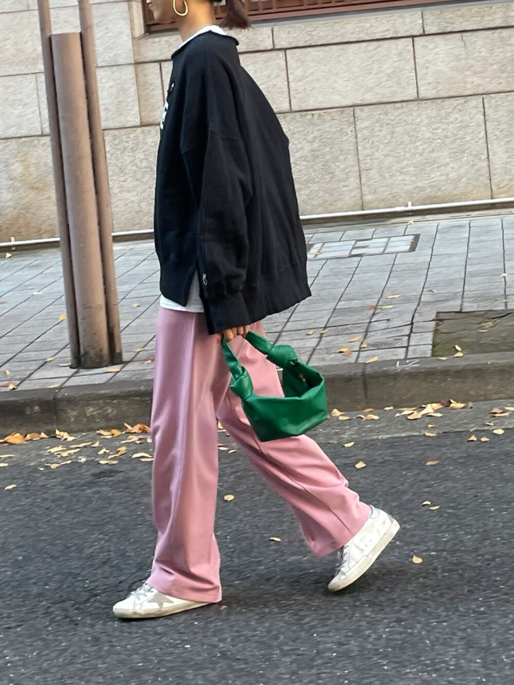 ピンク系のスラックス、ブラック系のスウェットを着用したレディースの秋コーディネートの2枚目の写真