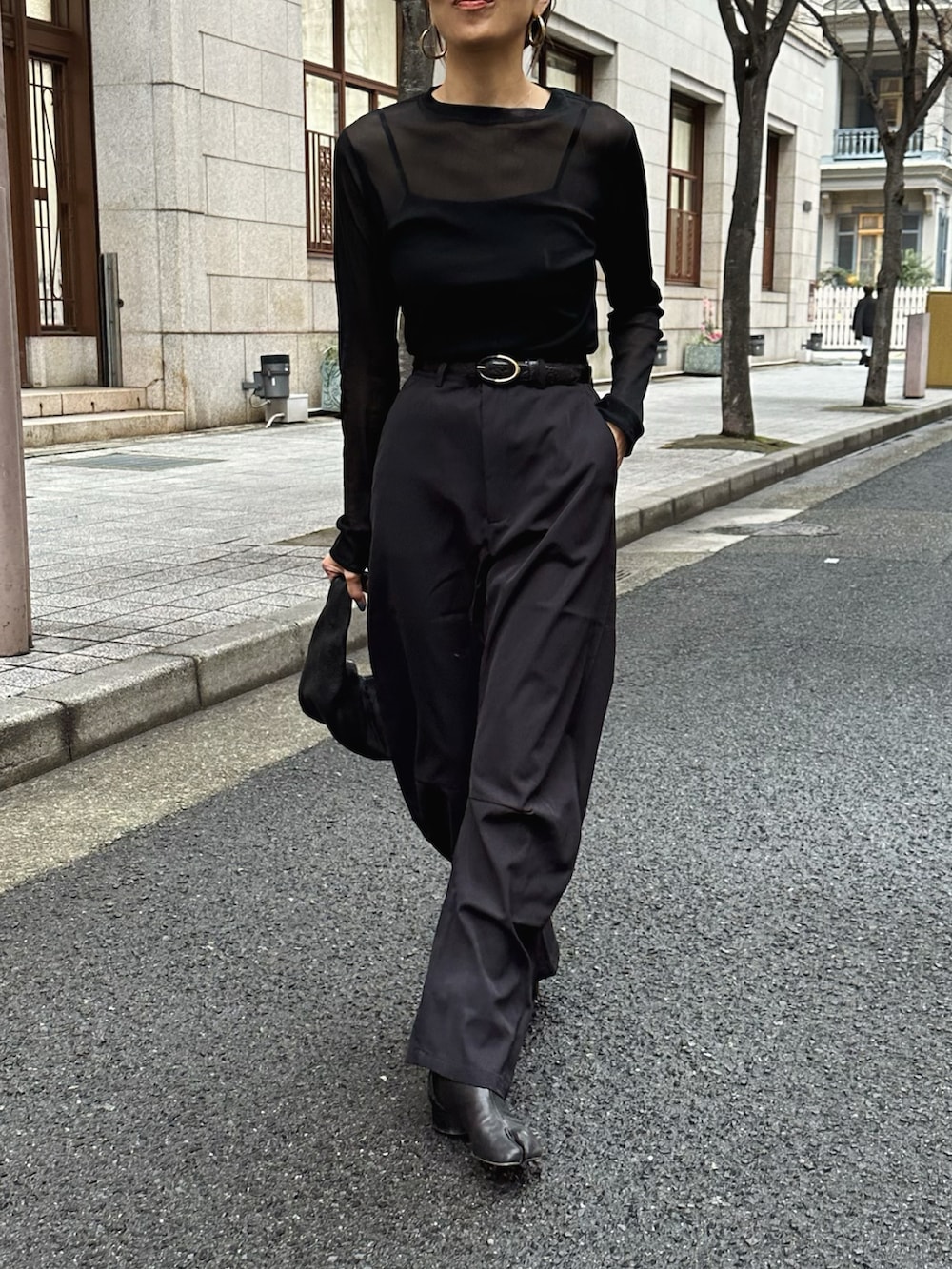 ブラック系のパンツ、ブラック系のブーツを着用したレディースの冬コーディネートの2枚目の写真