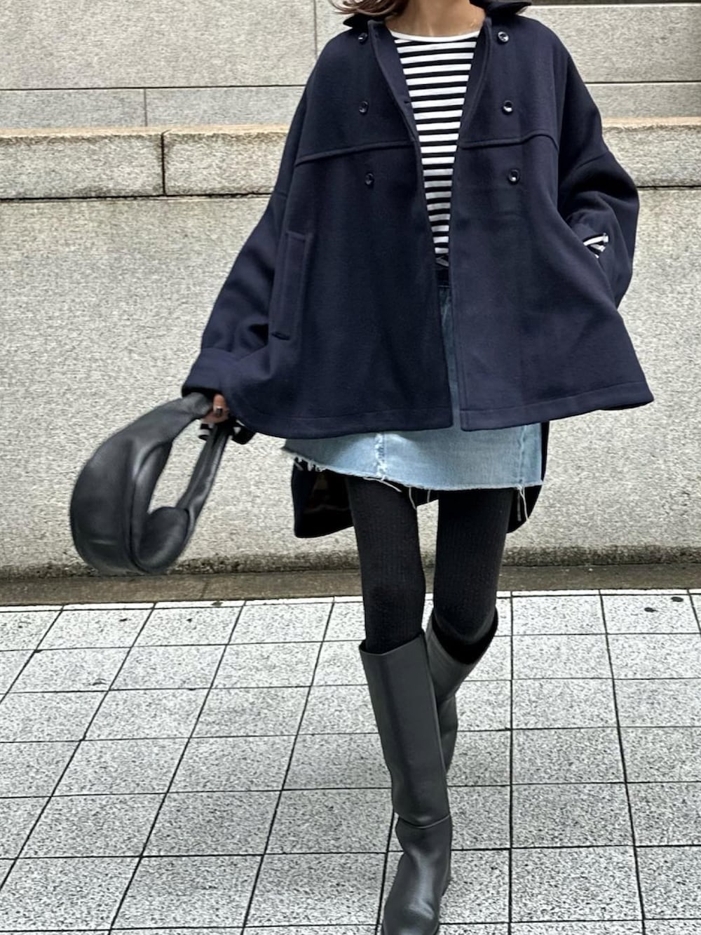 ブルー系のピーコート、ブラック系のブーツ、ブラック系のTシャツ/カットソーを着用したレディースの秋コーディネートの2枚目の写真