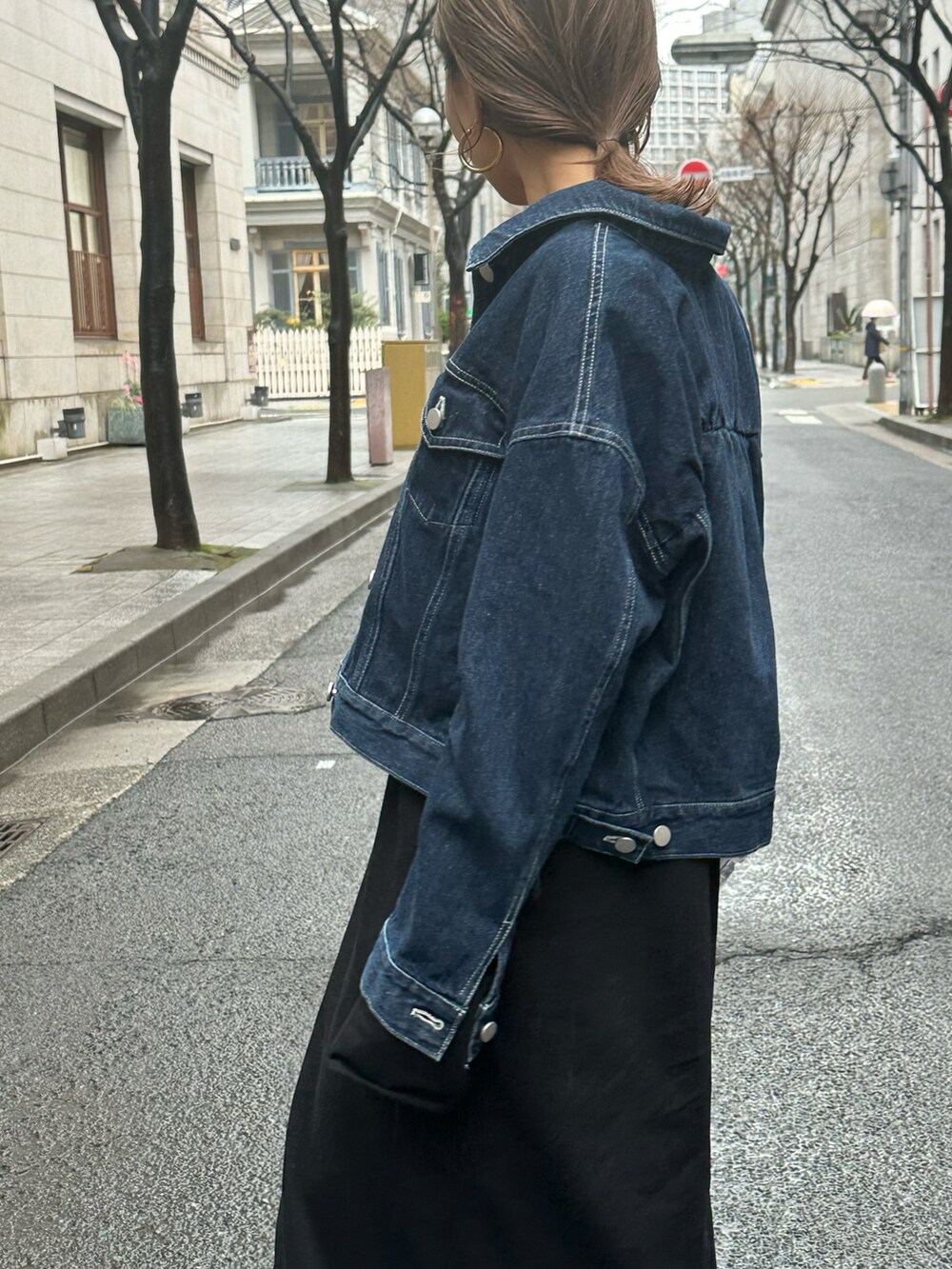 ブルー系のデニムジャケット、ブラック系のワンピースを着用したレディースの冬コーディネートの2枚目の写真