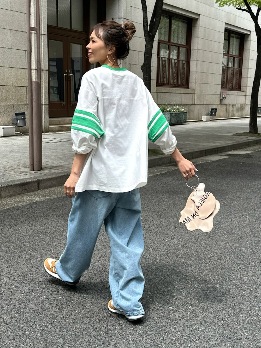 グリーン系のTシャツ/カットソー、ブルー系のデニムパンツ、イエロー系のスニーカーを着用したレディースの春コーディネートの2枚目の写真