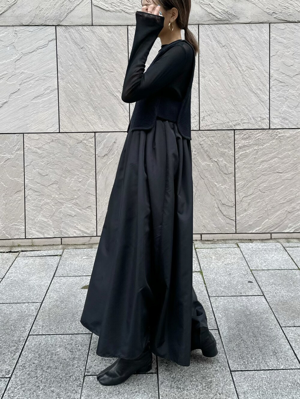 ブラック系のワンピース、ブラック系のTシャツ/カットソー、ブラック系のブーツを着用したレディースの冬コーディネートの2枚目の写真