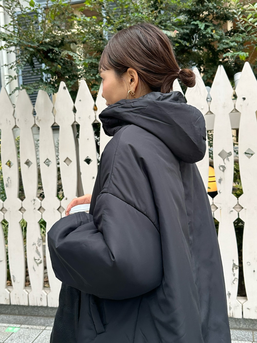 ブラック系のモッズコート、ブラウン系のパンツを着用したレディースの冬コーディネートの2枚目の写真