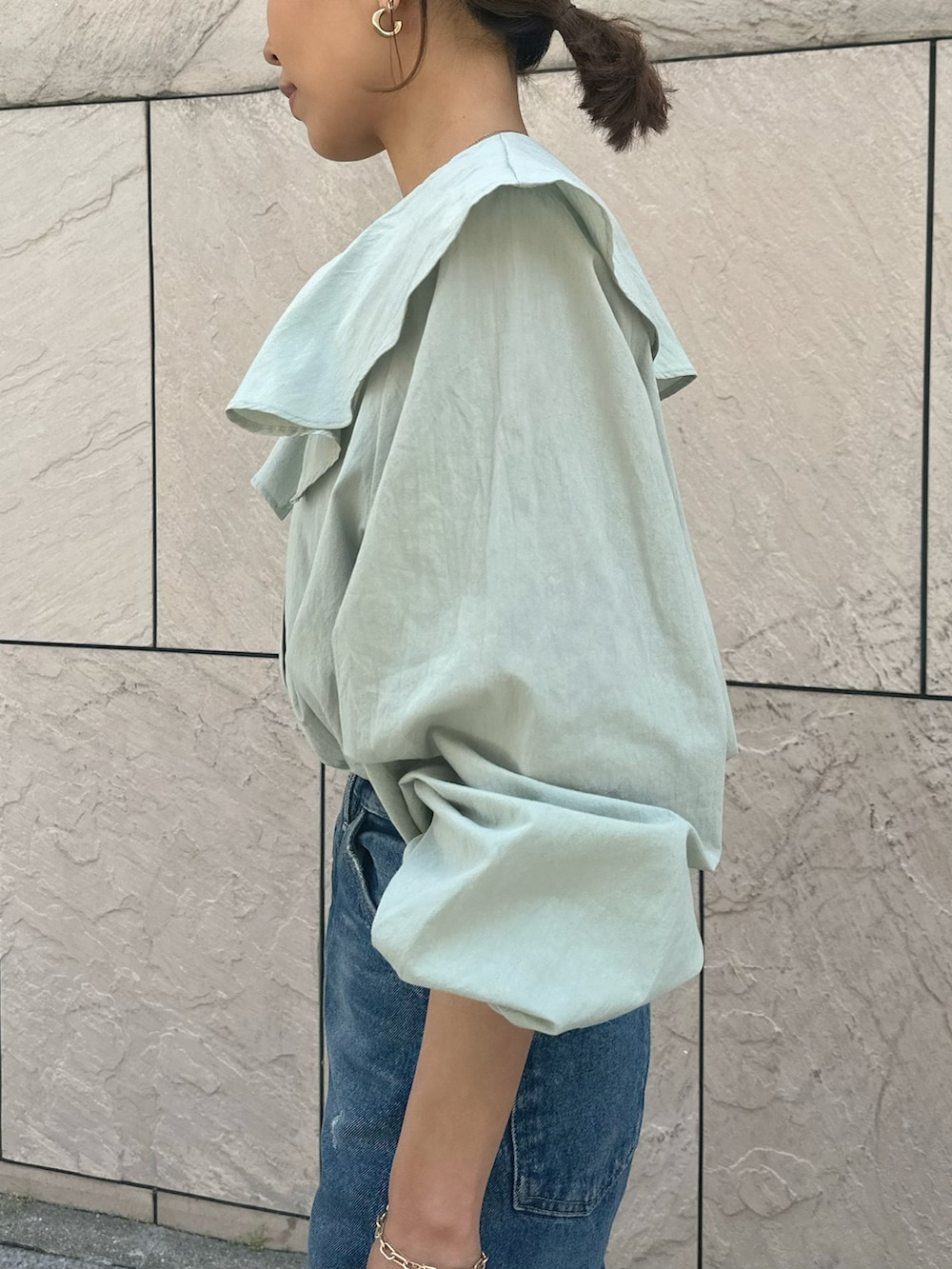 グリーン系のシャツ/ブラウス、ブルー系のデニムパンツ、ブラック系のサンダルを着用したレディースの春コーディネートの2枚目の写真