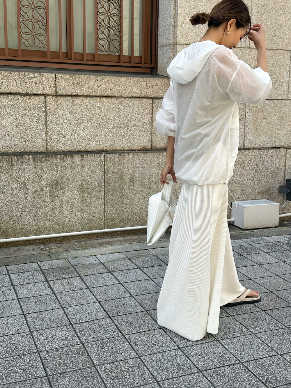 ホワイト系のパーカー、ホワイト系のスカート、ホワイト系のショルダーバッグを着用したレディースの春コーディネートの2枚目の写真