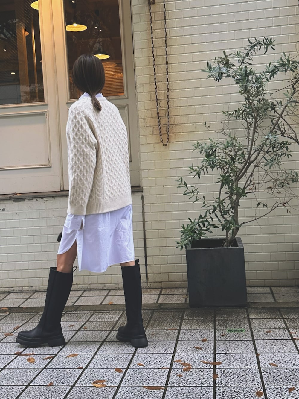 ブラック系のショルダーバッグ、ホワイト系のニット/セーター、ホワイト系のシャツ/ブラウスを着用したレディースの秋コーディネートの2枚目の写真